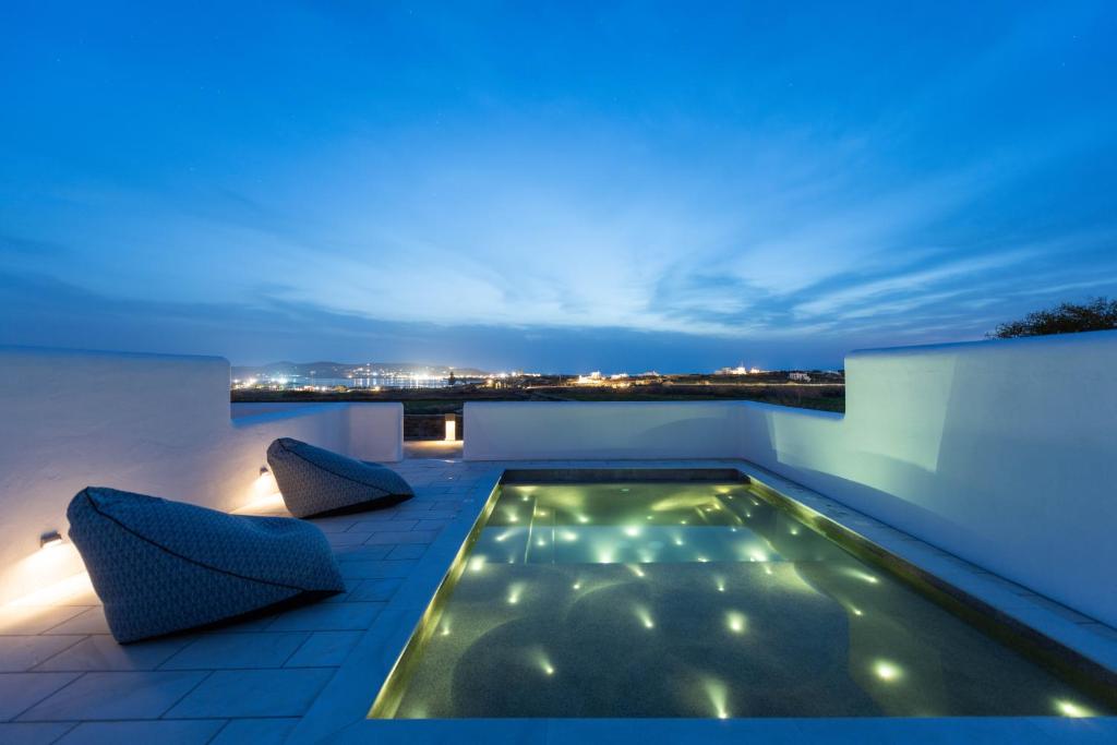 a swimming pool on the roof of a house at night at Sersi Paros Villas & Suites in Kampos Paros