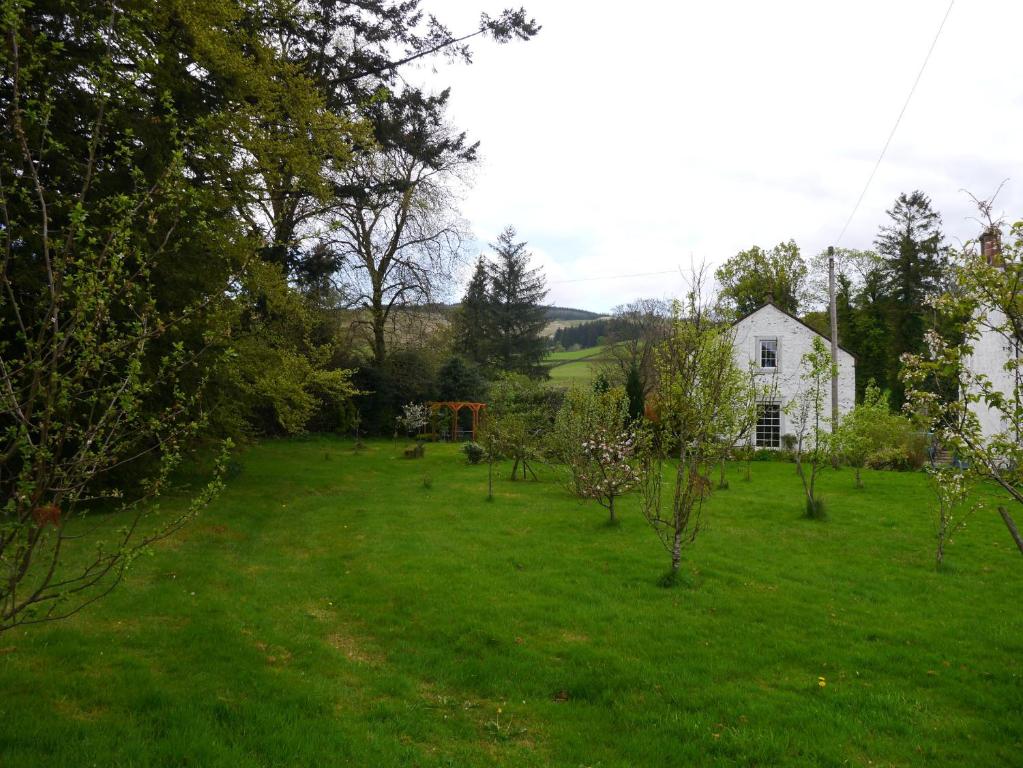 a large yard with a white house in the background at Old Coach House in Moniaive
