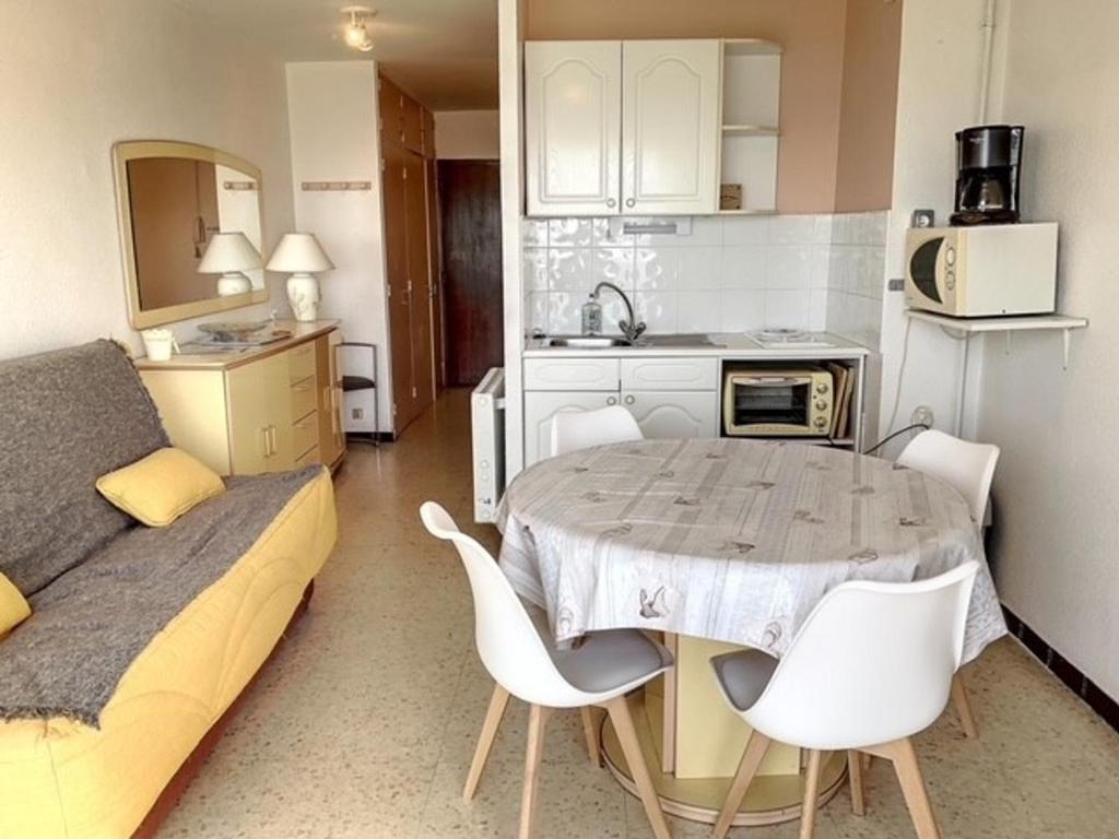 uma pequena cozinha com mesa e cadeiras num quarto em Studio Balaruc-les-Bains, 1 pièce, 4 personnes - FR-1-503-82 em Balaruc-les-Bains