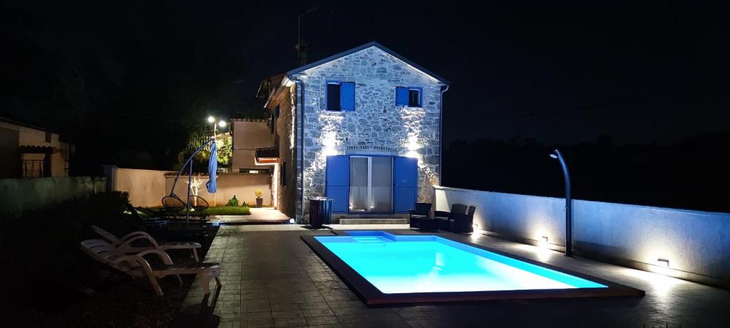 una piscina frente a una casa por la noche en Villa Allegra Velici, en Vižinada