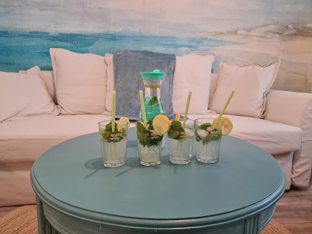 uma mesa azul com quatro frascos de vidro com plantas em Les Chouchous du Ried 2 em Saasenheim