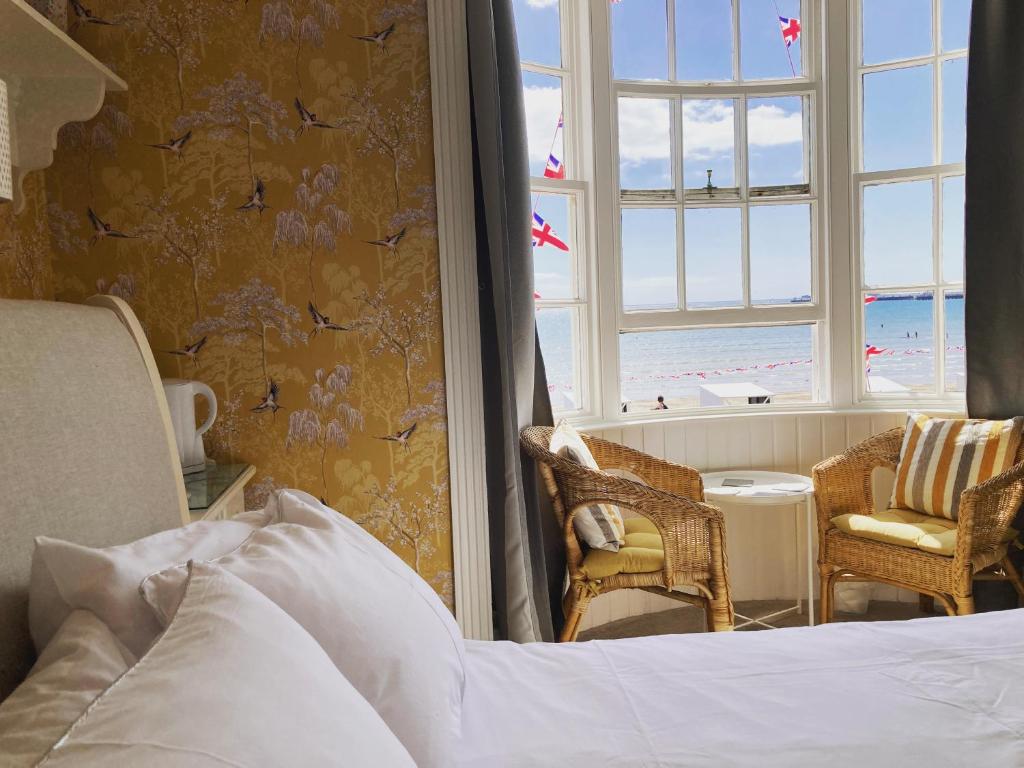 a bedroom with a bed and a view of the beach at Whitecliff Guest House in Weymouth