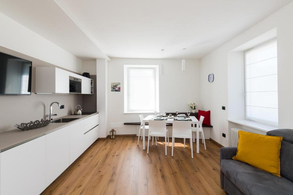 a kitchen and living room with a table and a couch at Appartamento Levico in Levico Terme