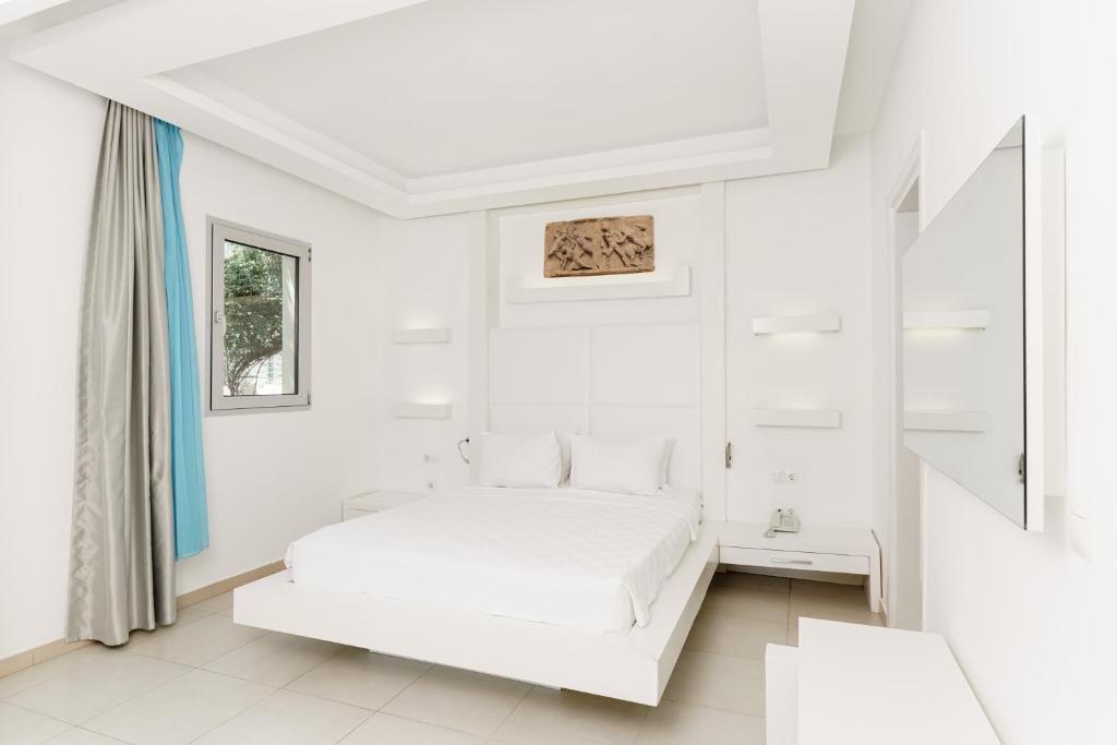 a white bedroom with a bed and a window at Costa Luvi Hotel Bodrum - All Inclusive in Gümbet