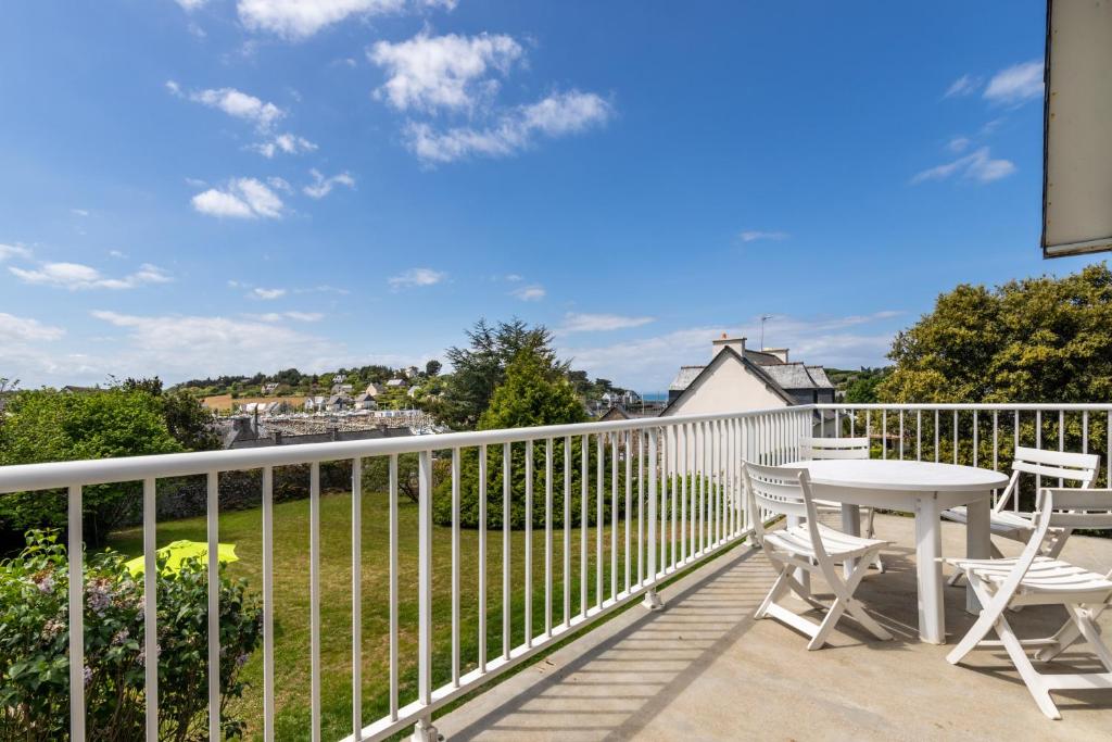 een patio met een tafel en stoelen op een balkon bij Jolie Brise in Pléneuf-Val-André