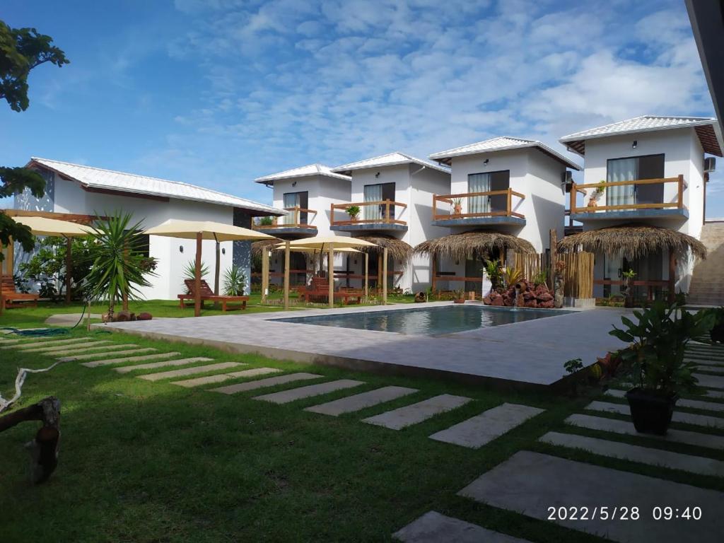 a resort with a swimming pool and a building at POUSADA CAJU DO MATO in Prado