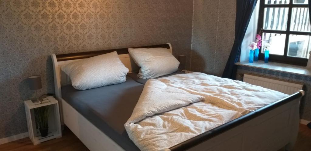 a bed with two pillows on it in a bedroom at FeWo Am Marktplatz in Zerf