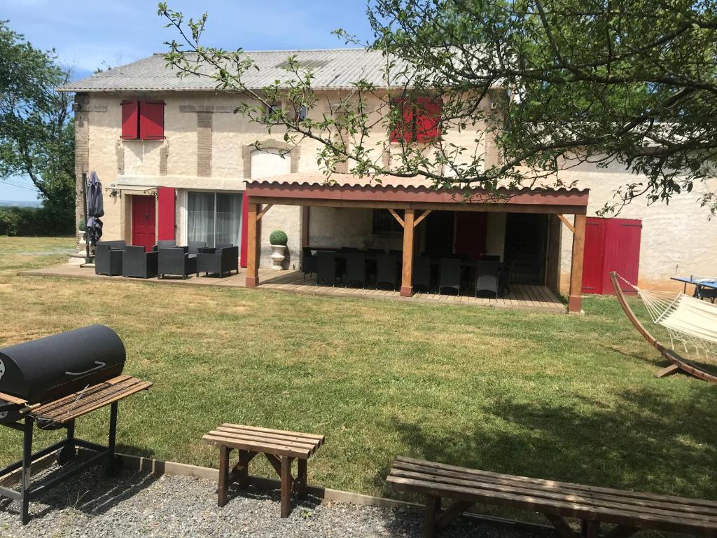 a building with a grill and a picnic table in a yard at La Bonne Mine in Le Fraysse