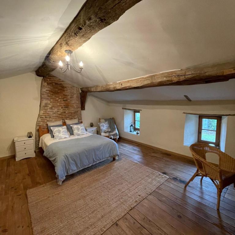 une chambre avec un lit et un mur de briques dans l'établissement Beautiful Cottage with private plunge pool/Hot Tub - 40 mins from Puy du Fou, à La Chapelle-Saint-Étienne