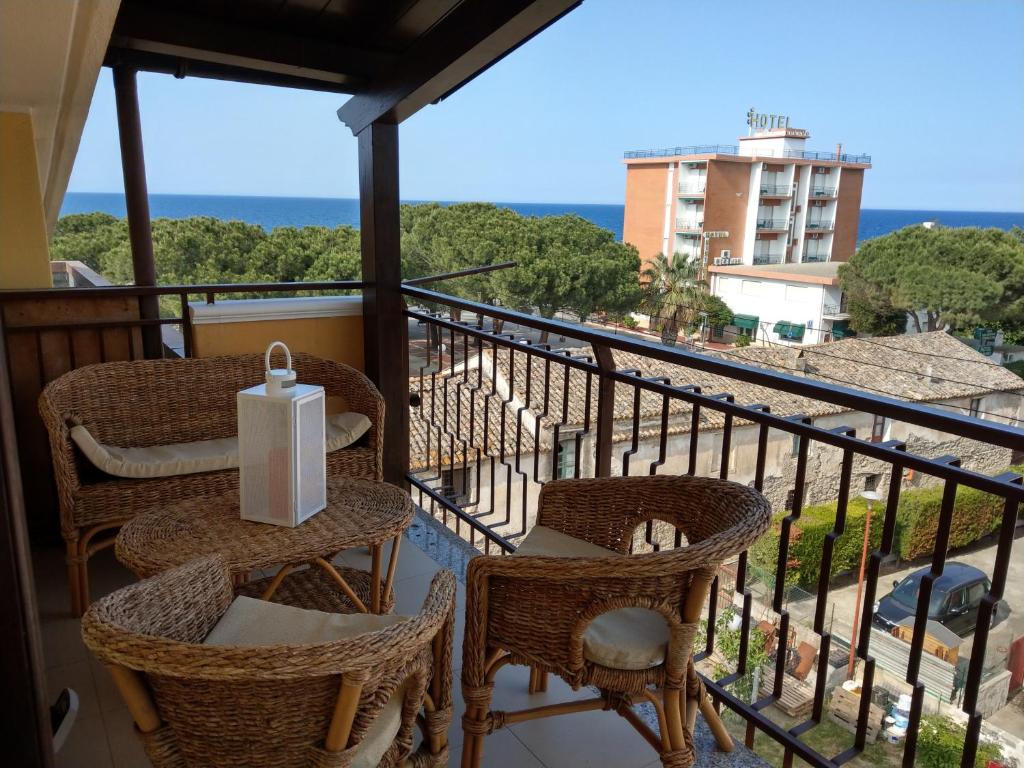 a balcony with chairs and a table with a view of the ocean at Franita in Rossano