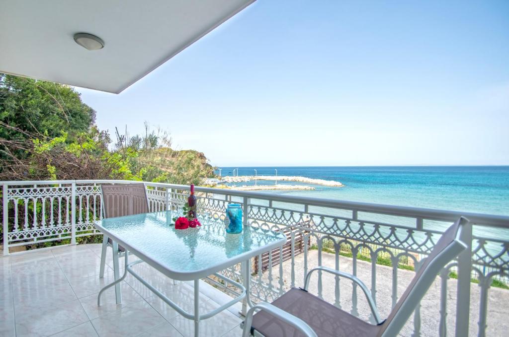 a table and chairs on a balcony overlooking the ocean at Ancora Beach House by "elite" in Tsilivi