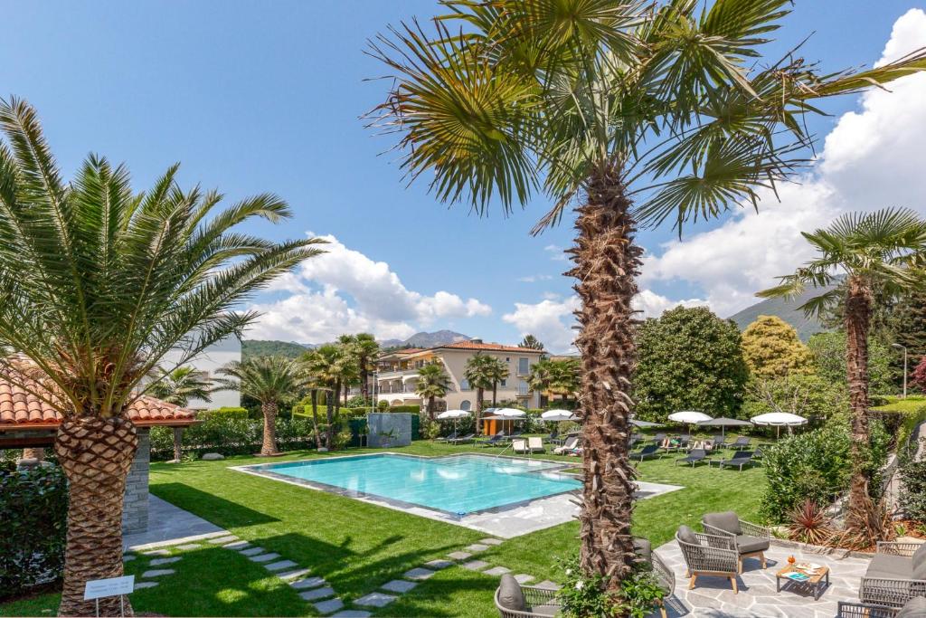 um resort com piscina e palmeiras em Hotel Ascovilla Charming Hideway em Ascona
