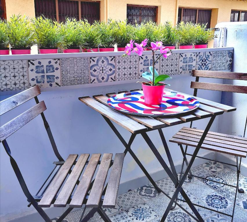 a table with two chairs and a flower pot on it at Vive Valencia con playa y metro cerca in Valencia