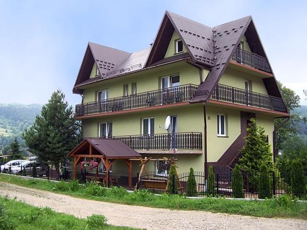 a large house with a gambrel roof on top of it at Pokoje gościnne u Bożenki in Krościenko