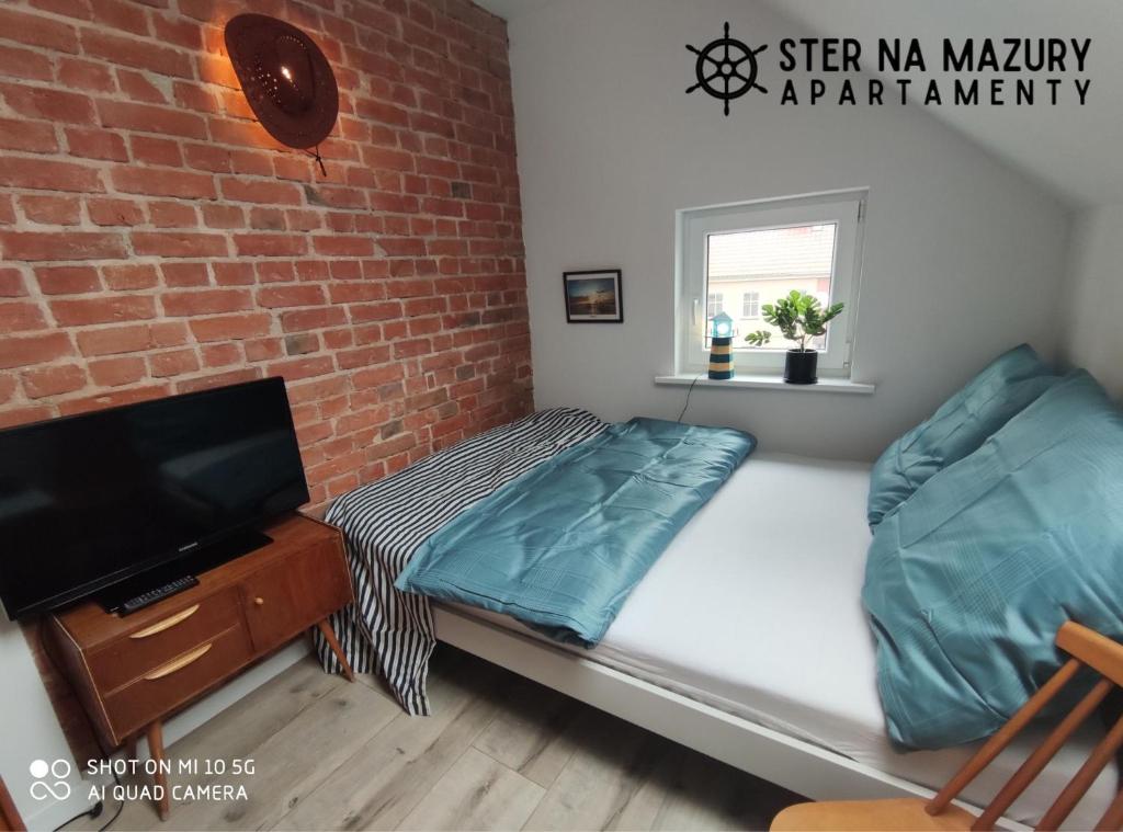 A bed or beds in a room at Ster na Mazury - apartamenty Mrągowo
