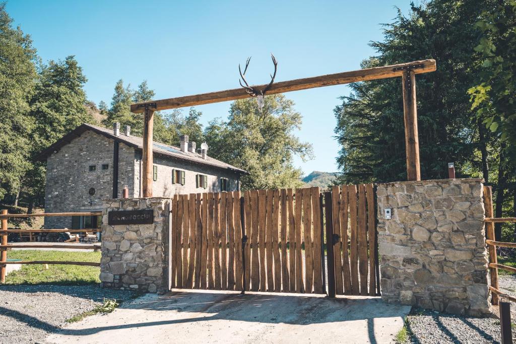 drewniana brama przed kamiennym płotem w obiekcie Rifugio Pian di Rocchi w mieście Corniolo