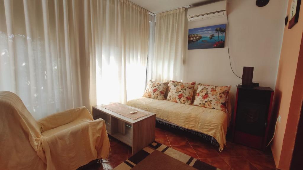 ein kleines Wohnzimmer mit einem Sofa und einem Stuhl in der Unterkunft Apartments Ruza in Budva