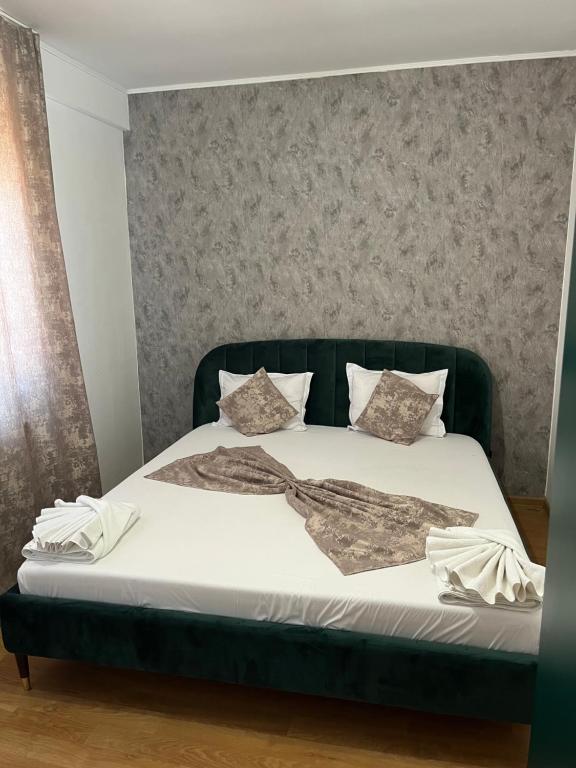 a bed with white sheets and pillows on it at Apartament de lux in Costinesti