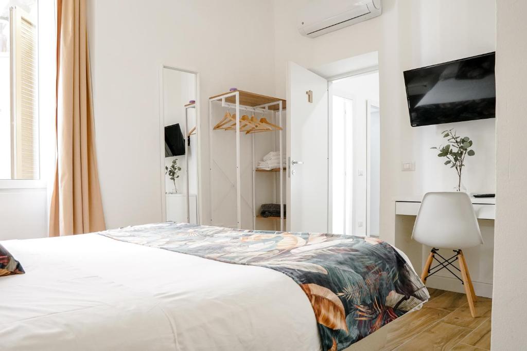ein weißes Schlafzimmer mit einem Bett und einem Stuhl in der Unterkunft Da Fede in Rom