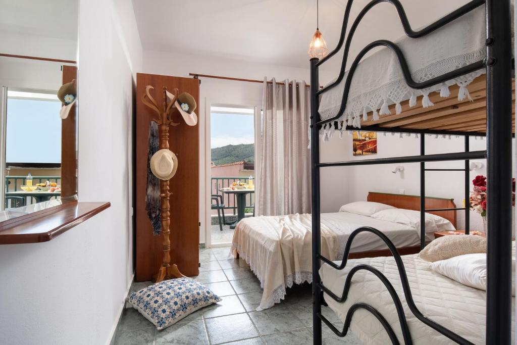 a bedroom with two bunk beds and a balcony at Studios Halkia in Toroni