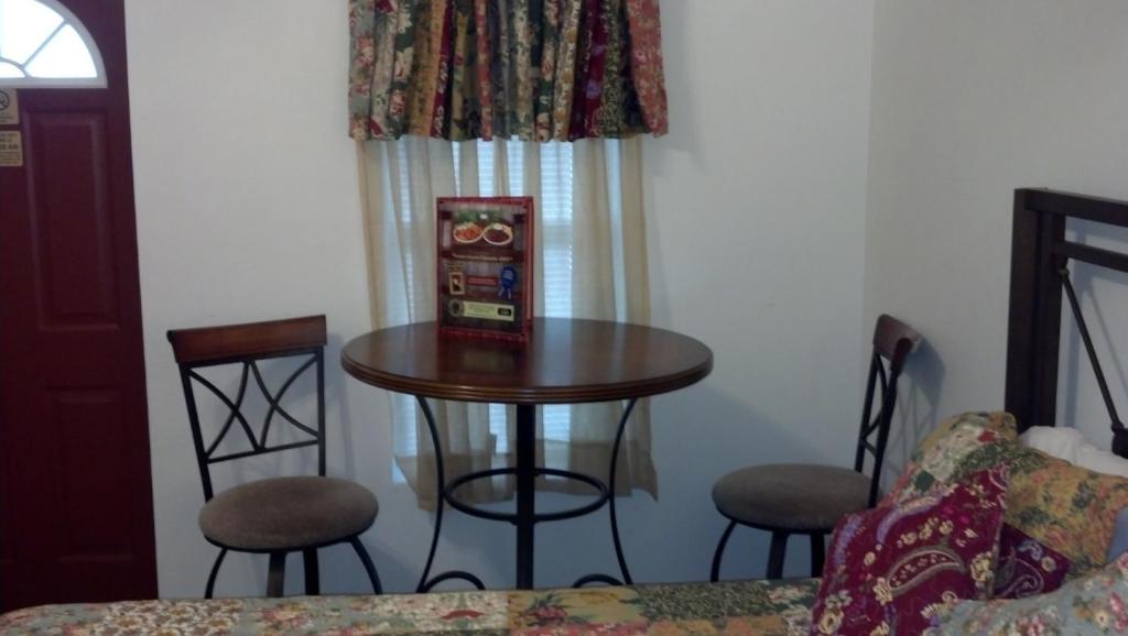 a small table and chairs in a room with a window at Buffalo Chip's Ranch House Motel in Bonita Springs