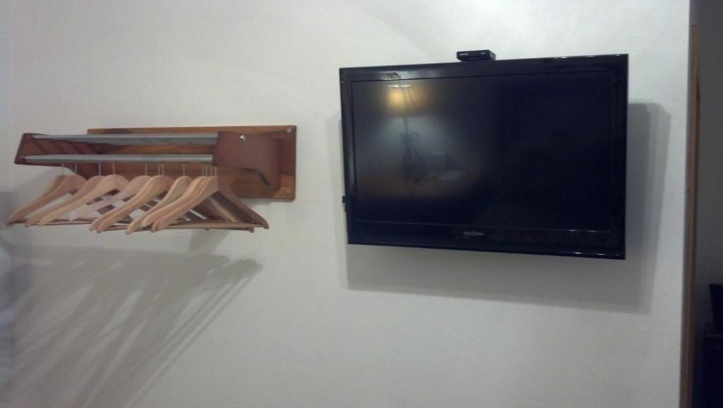 a flat screen tv hanging on a wall with wooden hangers at Buffalo Chip's Ranch House Motel in Bonita Springs