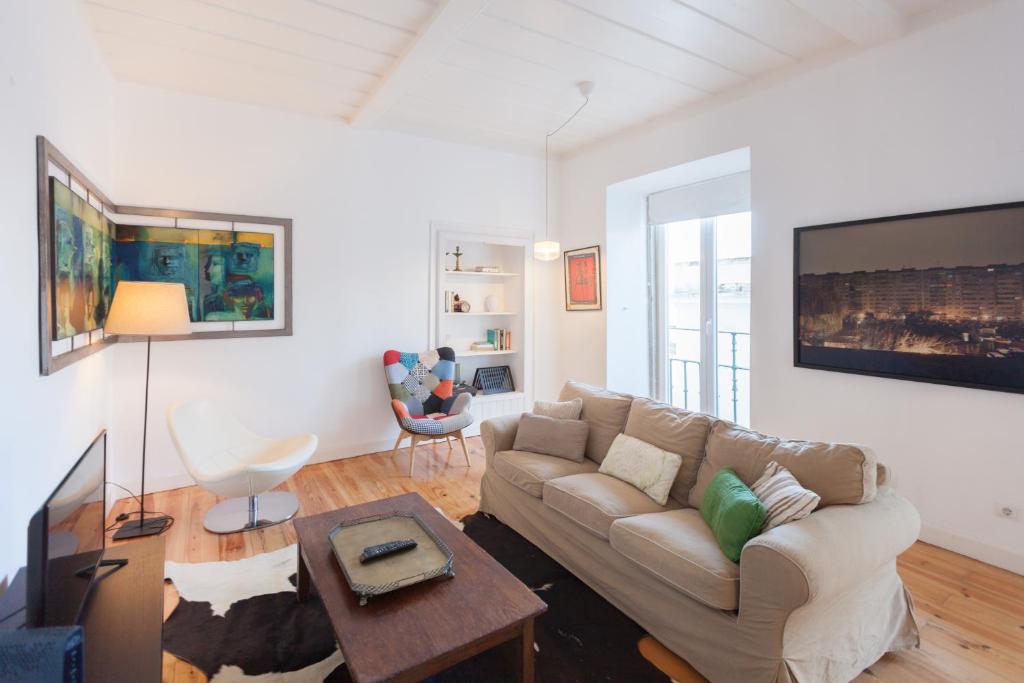 a living room with a couch and a tv at FLH São Jorge Castle Flat in Lisbon