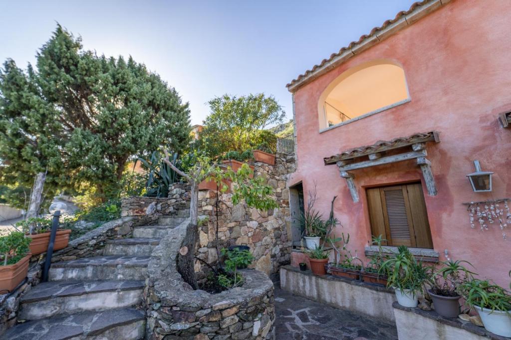 una casa de piedra con escaleras que conducen a un edificio en House in San Teodoro among the scents of Sardinia en San Teodoro