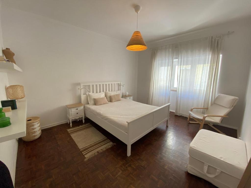 a bedroom with a white bed and a chair at Flora's Lisbon in Lisbon