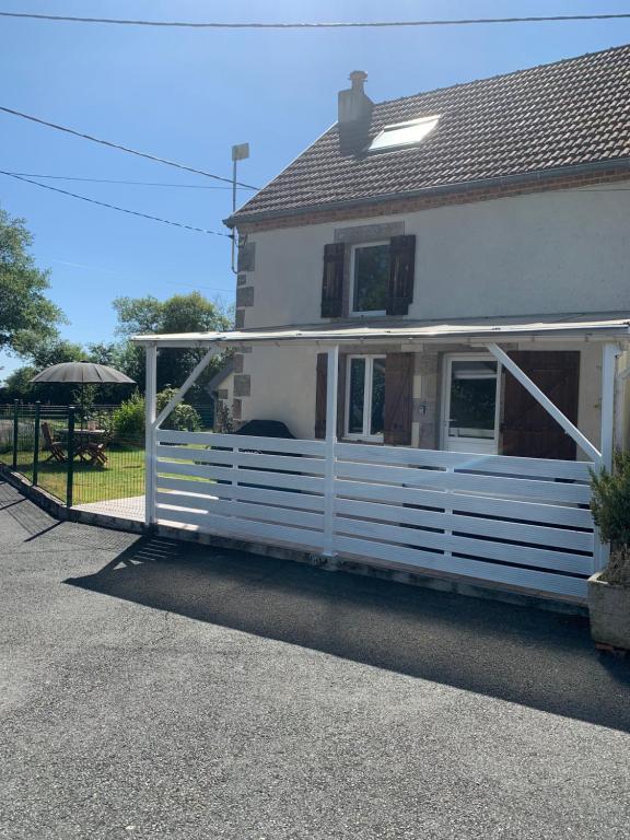 a white fence in front of a house at Swift Gites Creuse 