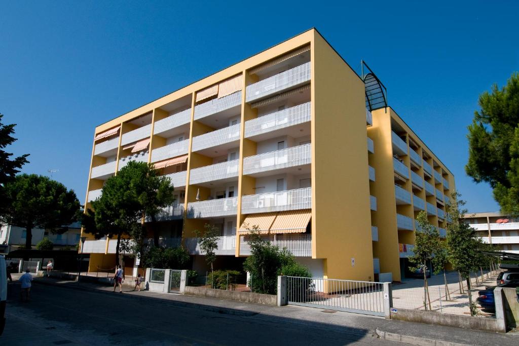 un immeuble d'appartements avec un jaune dans l'établissement Atlante, à Bibione