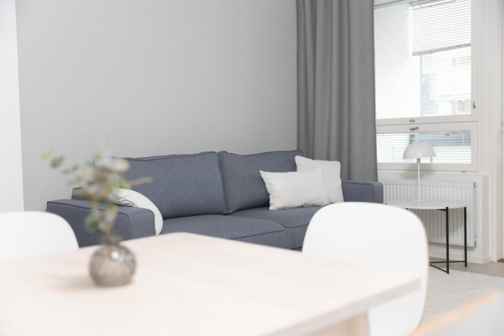 een woonkamer met een blauwe bank en een tafel bij Studio Leppälä in Rovaniemi