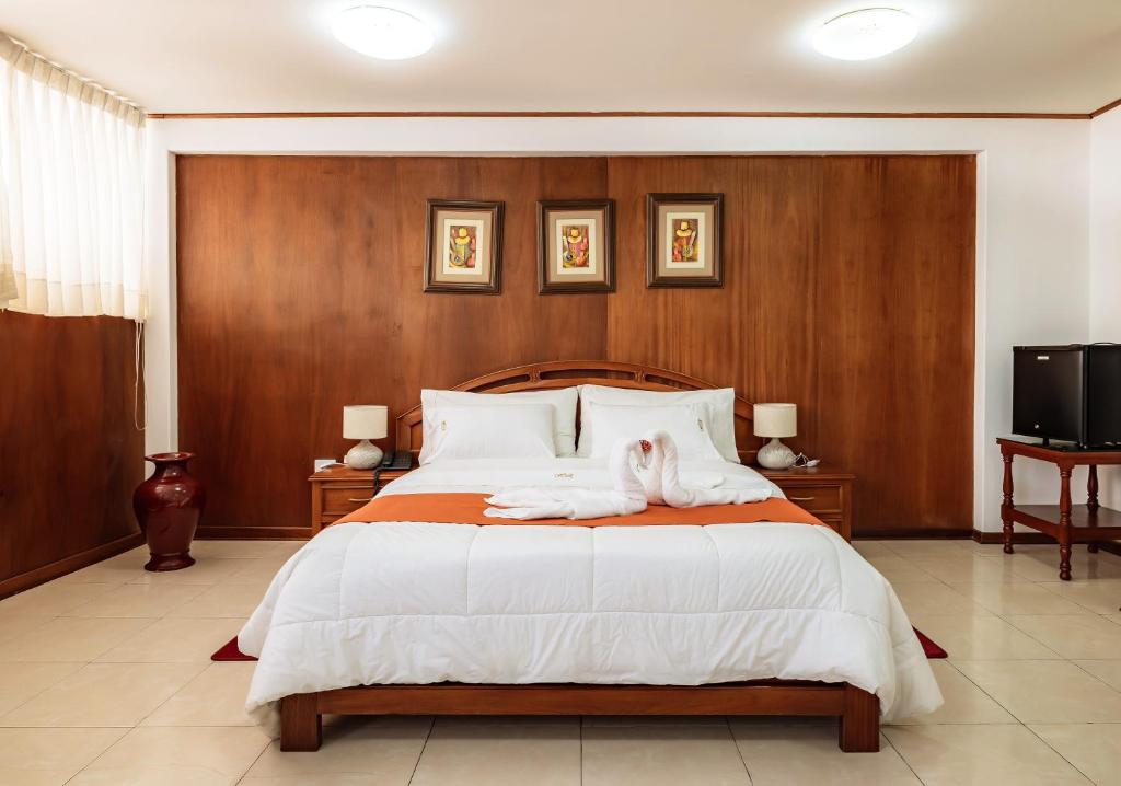 a bedroom with a large bed and a tv at Recreo Hotel in Trujillo