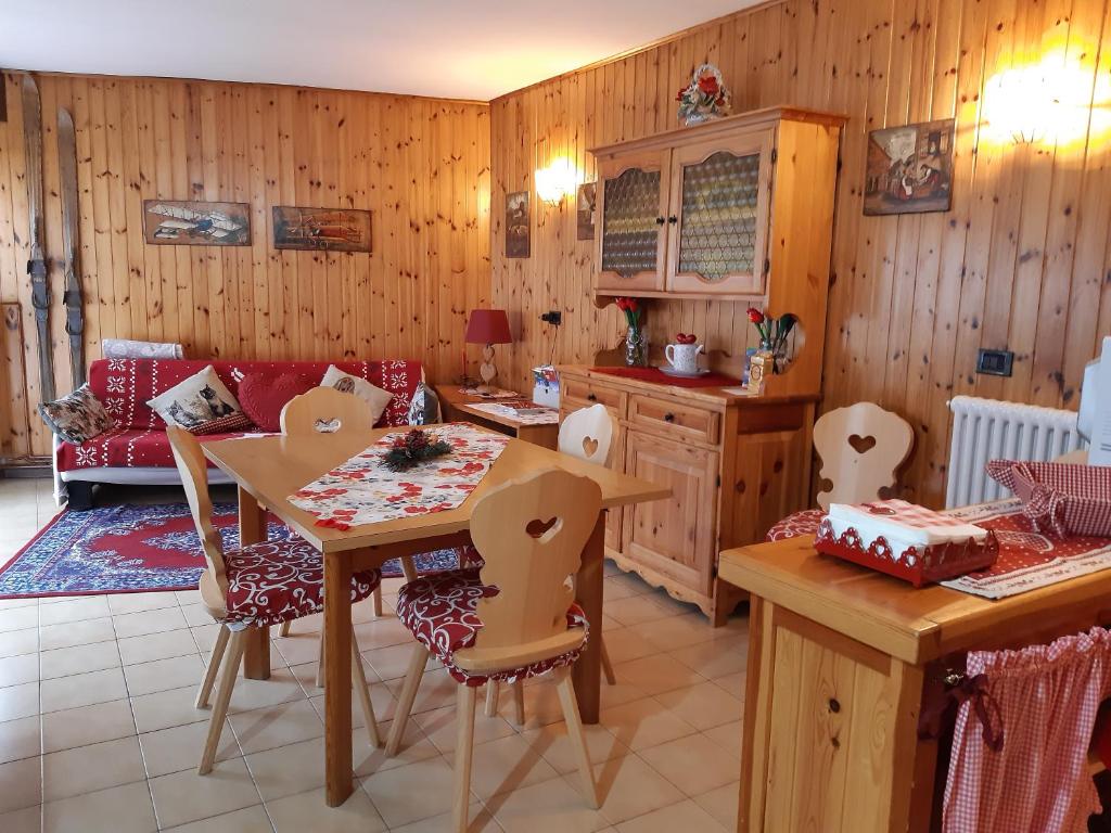 a kitchen with wooden walls and a table and chairs at Sella Ronda Apartment in Campitello di Fassa