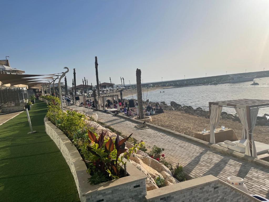 a beach with a row of tables and ailion and the water at Fleet Club Mahrousa in Alexandria