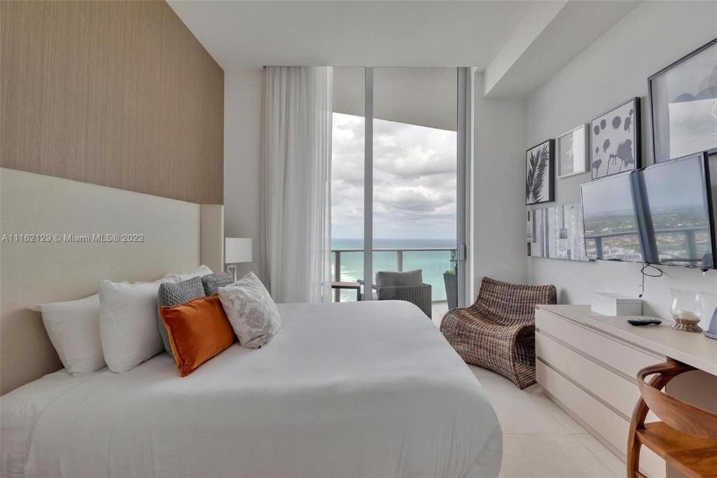 a bedroom with a large white bed and a desk at Penthouse Condo at Lyfe Resort and Residences in Hollywood