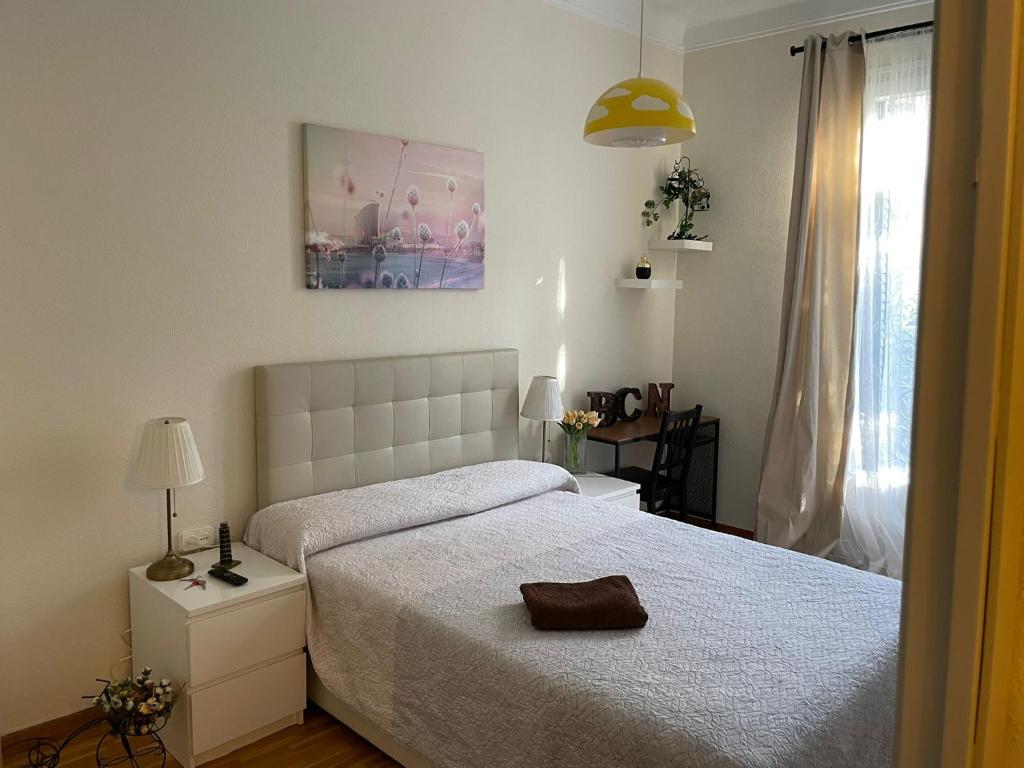ein weißes Schlafzimmer mit einem Bett und einem Fenster in der Unterkunft Rooms Aribau in Barcelona