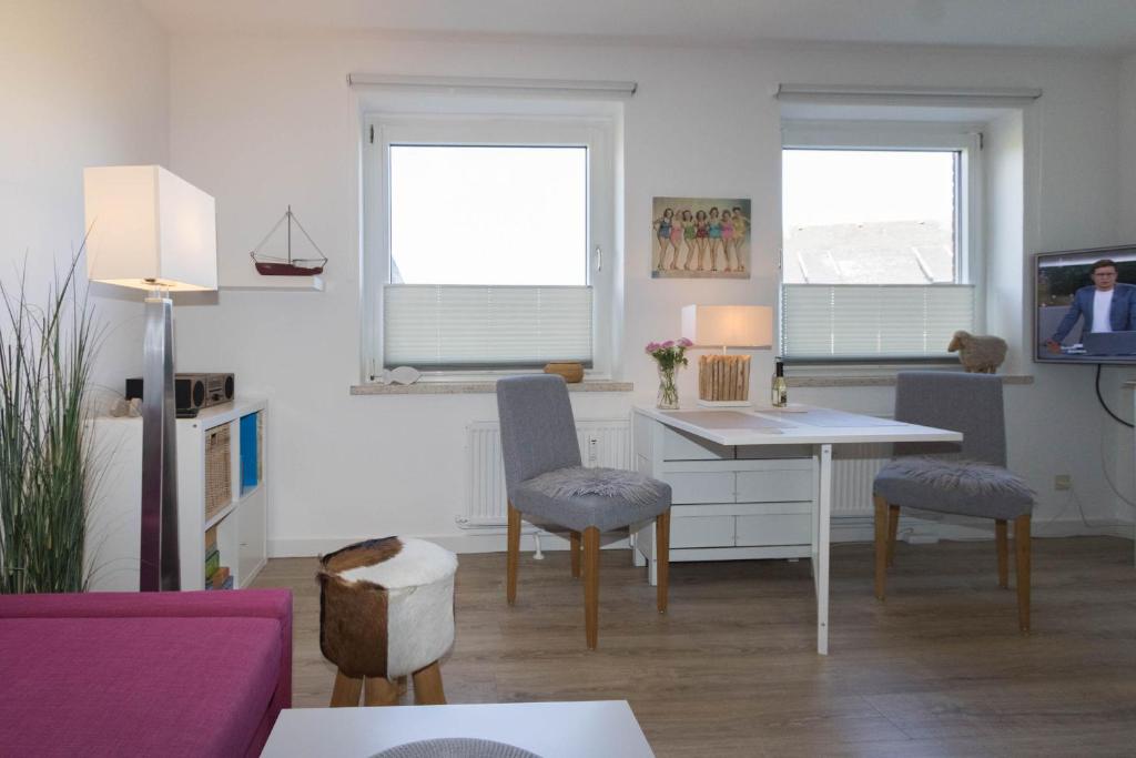a living room with a table and chairs and a tv at Ferienwohnung Bartram in Hörnum