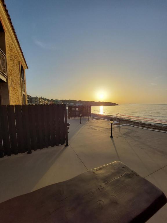 a sunset on the beach with the sun setting at Volakas Beachfront Suites in Rethymno