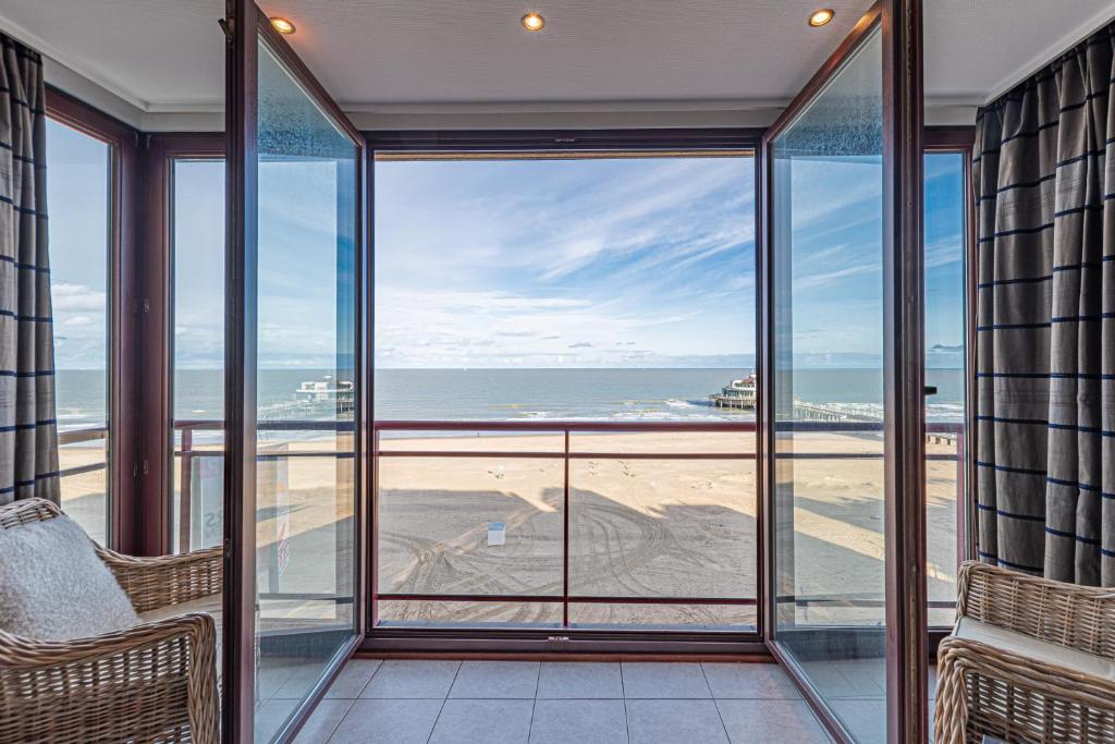 a view of the beach from the balcony of a house at Appartement Blankenberge Zeedijk aan de Pier in Blankenberge