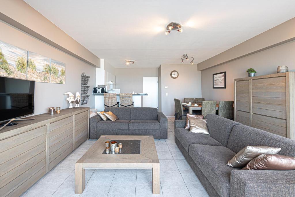 a living room with two couches and a tv at Appartement Blankenberge Zeedijk aan de Pier in Blankenberge