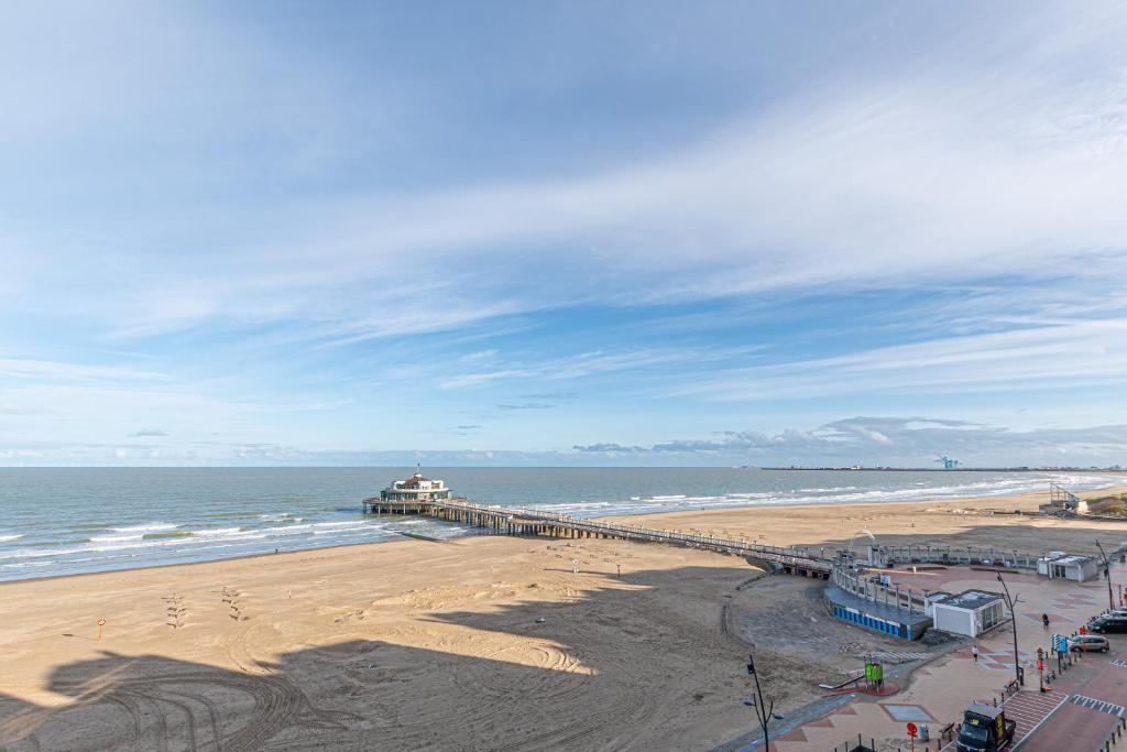 a view of a beach with a pier and the ocean at Appartement Blankenberge Zeedijk aan de Pier in Blankenberge