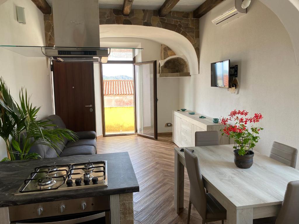 a kitchen and living room with a stove and a table at Casa Balilla in La Maddalena