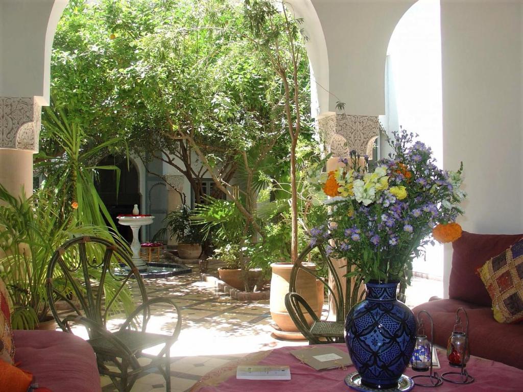 een woonkamer met een vaas met bloemen op een tafel bij Riad Sahara Nour in Marrakesh