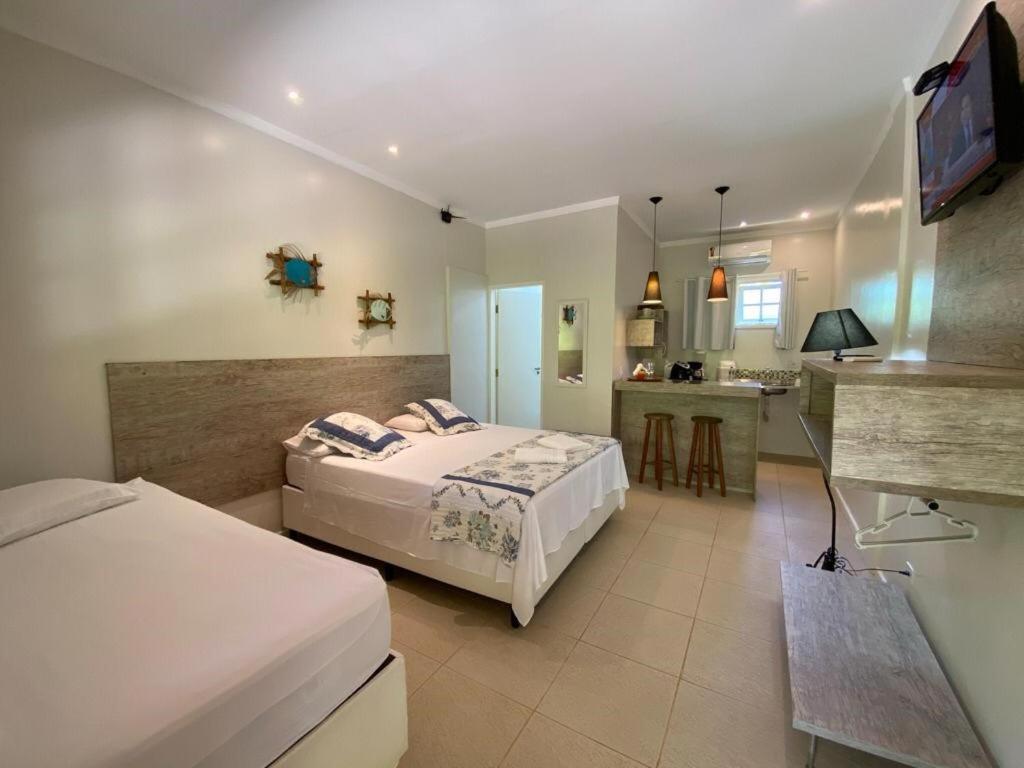 een hotelkamer met 2 bedden en een keuken bij Suites Prime Itamambuca in Ubatuba