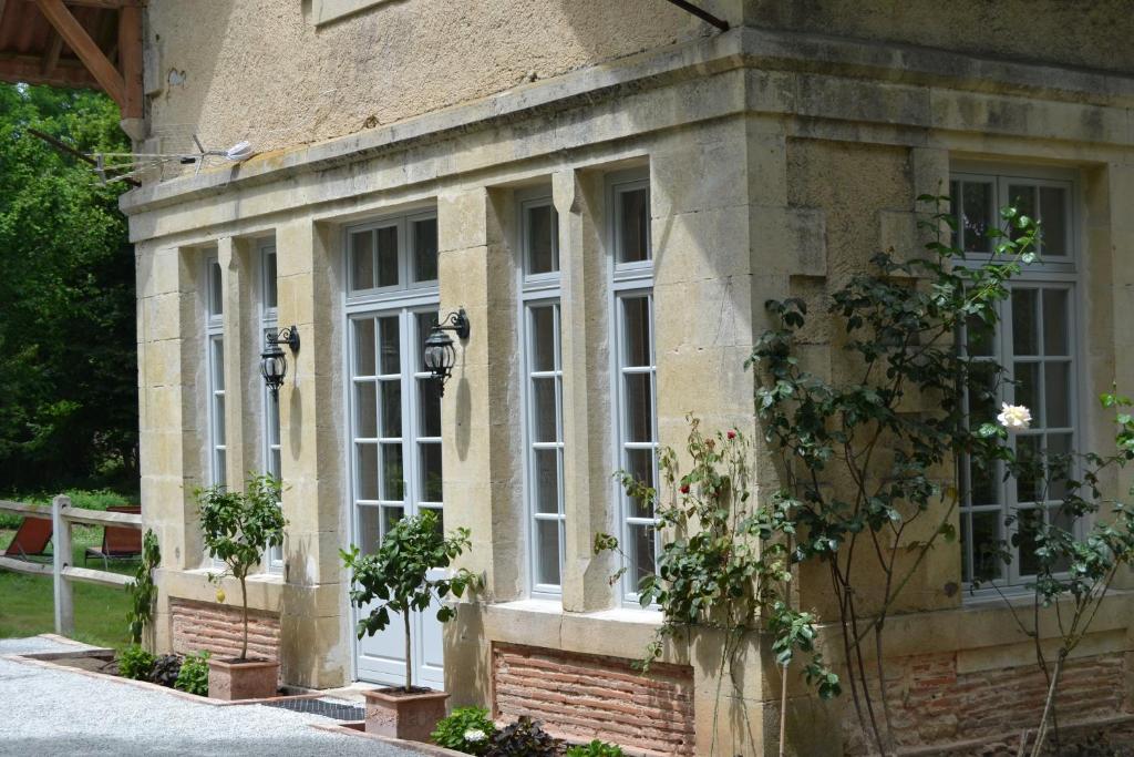 Saint-Justin的住宿－L'Orangerie, Château St Justin，建筑的侧面设有白色窗户