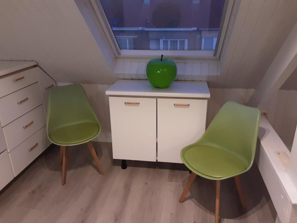 2 chaises et une pomme assise sur un bureau dans une pièce dans l'établissement Sixtyfour penthouse, à Knokke-Heist