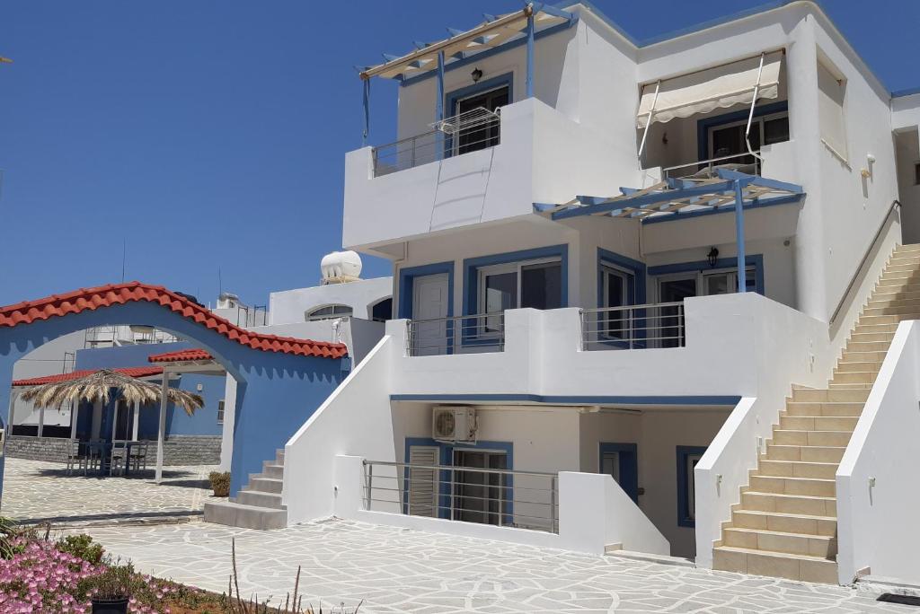 米拉托斯的住宿－Filia Apartments，海滩前有楼梯的大型白色建筑