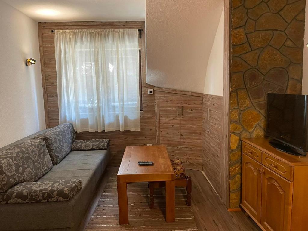 ein Wohnzimmer mit Sofa und Tisch in der Unterkunft Vila NADJA in Kopaonik