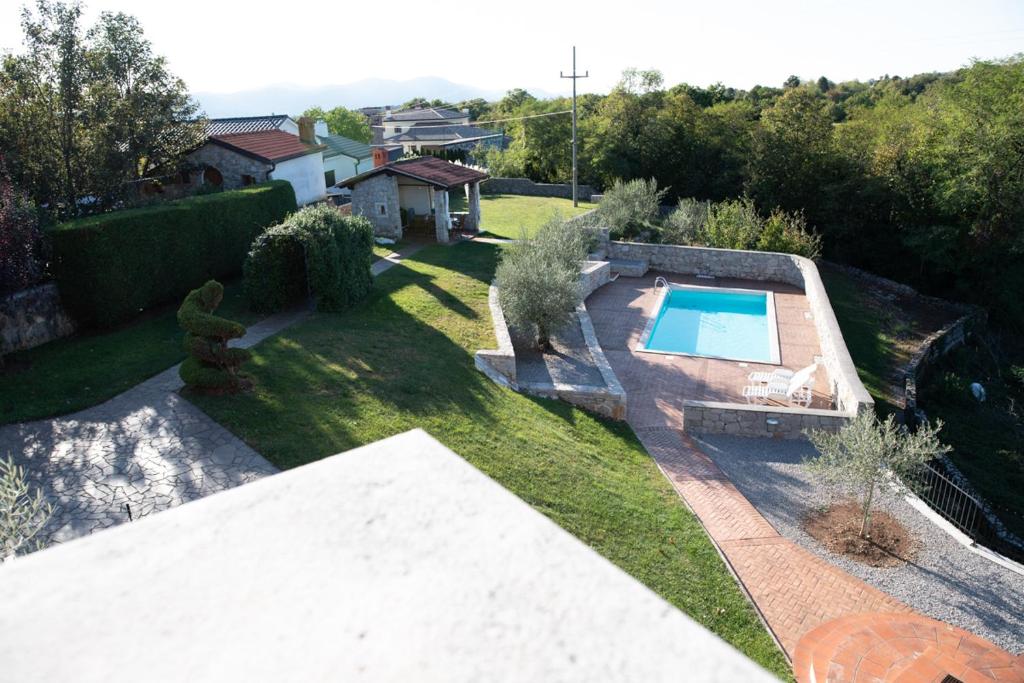 uma vista sobre um quintal com uma piscina em Castle house rooms, swimming pool & sauna & tennis court & wine cellar em Sežana